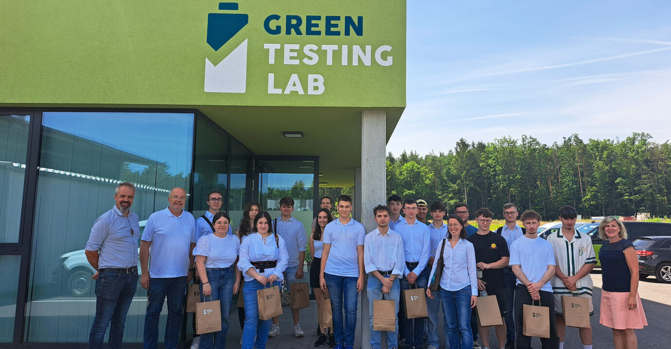 Gruppenfoto mit 18 Schüler:innen und zwei Lehrer der HTL Pinkafeld und Elisabeth und Max vor dem Green Testing Lab Betriebsgebäude